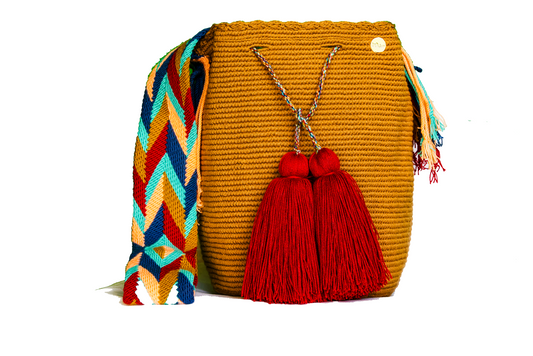Handmade Caramel Handbag with Patterned Handel. this crochet bag has 2 deep red tassels 